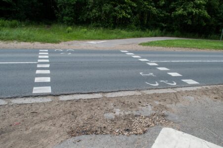 Pie tam bīstamajā šķērsojumā veloceļam ir ļoti slikta ceļa seguma kvalitāte, kas rada papildu drošības riskus.