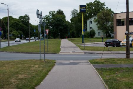 Turpinājumā "veloceļš" šķērso brauktuvi un, atbilstoši CSN, velosipēdists to nemaz nedrīkst pārbraukt, jo tādējādi nāktos šķērsot nepārtrauktu balto līniju.