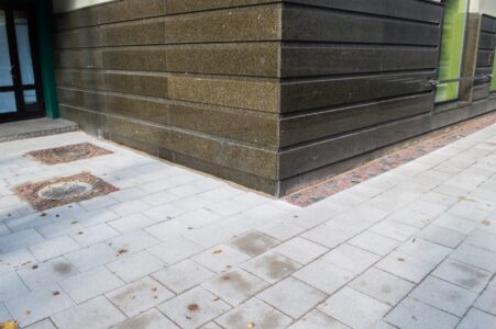 Rupjais granīta bruģis ieklāts haotiski - pat pie vienas ēkas fasādes tas gan ir, gan nav.