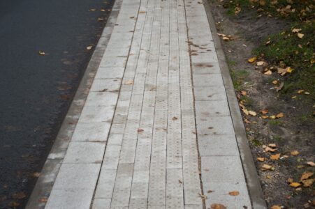 Duntes ielā praktiski visu ietves platumu aizņem taktilais bruģis, kas brīdina par bīstamo zonu aiz tā.