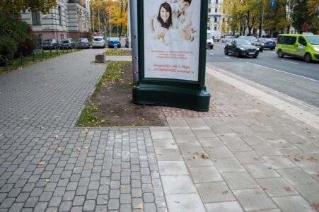 To mierīgi būtu iespējams novietot zaļajā labiekārtojuma joslā, lai tas neatrastos uz ietves efektīvās joslas.
