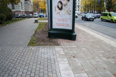 To mierīgi būtu iespējams novietot zaļajā labiekārtojuma joslā, lai tas neatrastos uz ietves efektīvās joslas.