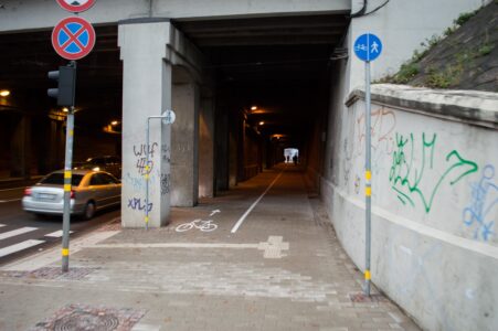 Tunelī sākas ar baltas krāsas līniju nodalīts gājēju un velosipēdu ceļš. Kāpēc šeit netika izveidots ar apmalēm nodalīts, asfaltēts veloceļš?